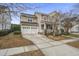 Two-story house with gray siding, white double garage doors, and landscaping at 705 Quintan St, Summerville, SC 29486