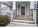 Front porch with brick columns, white railings, and dark brown door at 705 Quintan St, Summerville, SC 29486
