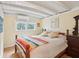 Cozy bedroom with wood floors and beamed ceiling at 904 E Arctic Ave, Folly Beach, SC 29439