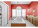 Bathroom with a large tub, double vanity, and coral walls at 927 Fishburne Rd, Pinopolis, SC 29469