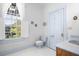 Light blue bathroom with toilet, window, and wood vanity at 927 Fishburne Rd, Pinopolis, SC 29469