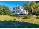 White house with red roof, landscaping, and brick well at 927 Fishburne Rd, Pinopolis, SC 29469