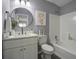 Updated bathroom with white vanity and a round mirror at 117 Hummingbird Ave, Ladson, SC 29456