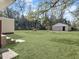 Expansive green backyard features a shed, wooded perimeter, and fire pit ready for outdoor enjoyment at 138 Green Pond Hwy, Walterboro, SC 29488