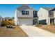 Two-story house with gray and beige siding, a white garage door, and landscaping at 307 Black Birch Dr, Summerville, SC 29486