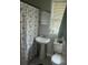 Bathroom with pedestal sink, butterfly-themed shower curtain, and window at 310 Adeline Dr, Goose Creek, SC 29445