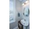 Charming pedestal sink bathroom with a round mirror and window at 4240 William E Murray Blvd, Charleston, SC 29414