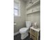 Small bathroom with white toilet and pedestal sink, floating shelves, and dark tile floor at 4334 Bream Rd, North Charleston, SC 29418
