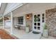 Inviting front porch with brick columns, a white door, and potted plants at 4334 Bream Rd, North Charleston, SC 29418