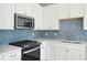 Modern kitchen features black appliances and a herringbone tile backsplash at 482 Queenview Ln, Charleston, SC 29414