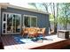 Wooden back deck with an outdoor dining set on a blue rug, with a light blue house in the background at 5242 Potomac St, North Charleston, SC 29405