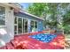 Red deck with blue rug and chairs, overlooks a fenced backyard at 5242 Potomac St, North Charleston, SC 29405
