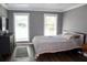Bright bedroom featuring two windows, hardwood floors, and stylish gray decor at 5242 Potomac St, North Charleston, SC 29405