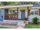 Quaint front porch with blue door, wooden railing, and colorful flower boxes at 5242 Potomac St, North Charleston, SC 29405