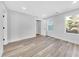 Well-lit bedroom featuring wood-look floors and large windows at 5889 N Rhett Ave, Hanahan, SC 29410