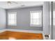 Bright bedroom with hardwood floors, ceiling fan, and two windows at 917 S Main St, Summerville, SC 29483