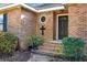 Brick entryway with black door, circular window, and landscaping at 917 S Main St, Summerville, SC 29483