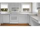 White kitchen with wood floors, appliances, and ample counter space at 917 S Main St, Summerville, SC 29483