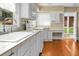 White kitchen with wood floors, built-in desk, and sunroom access at 917 S Main St, Summerville, SC 29483