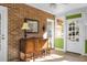 Sunroom with brick walls, wood floors, and vintage buffet at 917 S Main St, Summerville, SC 29483