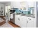 White kitchen cabinets, granite countertops, and a farmhouse sink at 9772 Berrywood Dr, Ladson, SC 29456