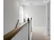 Upstairs hallway with wood railing and neutral colored walls at 149 Cypress Preserve Blvd, Moncks Corner, SC 29461