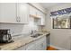 Clean kitchen with white cabinets, granite counters, and stainless steel appliances at 149 High Hammock Villas, Seabrook Island, SC 29455