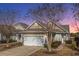 Tan colored home with white garage door and landscaping at 234 Sea Lavender Ln, Summerville, SC 29486