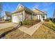 Tan colored home with white garage door and landscaping at 234 Sea Lavender Ln, Summerville, SC 29486