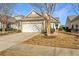 Tan colored home with white garage door and landscaping at 234 Sea Lavender Ln, Summerville, SC 29486