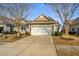 Tan house with white garage door and landscaping, located on a quiet street at 234 Sea Lavender Ln, Summerville, SC 29486