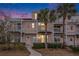 Three-story peach building with white trim, balconies, and palm trees at dusk at 2978 Sugarberry Ln, Johns Island, SC 29455