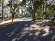 Paved road through a wooded area with homes visible at 345 Sea Cloud Cir # 345, Edisto Island, SC 29438