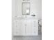 White bathroom vanity with marble countertop and herringbone floor tiles at 507 Mccants Dr, Mount Pleasant, SC 29464