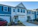 Two-story townhome with gray and white siding, two-car garage, and landscaping at 553 Trotters Ln, Moncks Corner, SC 29461