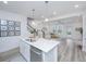 Modern kitchen with white cabinets, island, and open living area at 553 Trotters Ln, Moncks Corner, SC 29461