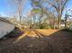 Large backyard with leaf covered lawn and mature trees surrounding at 7640 Hillview Ln, North Charleston, SC 29420