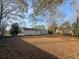 Backyard view of house, showcasing a large lawn with scattered leaves at 7640 Hillview Ln, North Charleston, SC 29420