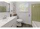 Clean bathroom with white vanity, olive green tile, and updated fixtures at 7640 Hillview Ln, North Charleston, SC 29420