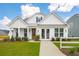 White farmhouse exterior with a brown door, landscaping, and walkway at 780 Opal Wing St, Moncks Corner, SC 29461