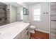 Modern bathroom with double vanity, walk-in shower, and wood-look floors at 826 Rue Dr, Charleston, SC 29414