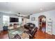 Open living room with hardwood floors, leather sofas, and kitchen view at 826 Rue Dr, Charleston, SC 29414