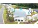 Aerial view of a community pool with modern architecture, lounge chairs, and a serene pond at 9761 Transplanter Cir, Ladson, SC 29456