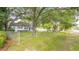 White house with grey roof, surrounded by trees and a chain link fence at 1225 Central Ave, Summerville, SC 29483