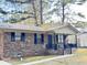 Brick ranch house with a covered porch, dark shutters, and a landscaped yard at 1401 Rivers St, Walterboro, SC 29488