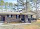 Brick ranch house with a covered porch, dark shutters, and a landscaped yard at 1401 Rivers St, Walterboro, SC 29488