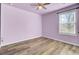 Light purple walls, wood-look floors, and a window with blinds create a serene bedroom at 145 Clydesdale Cir, Summerville, SC 29486