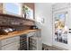 Wet bar with wine cooler, custom shelving, and access to backyard at 1493 Nautical Chart Dr, Charleston, SC 29414
