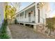 White cottage with a spacious front porch, brick pathway, and a fenced yard at 17 H St, Charleston, SC 29403