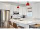 White kitchen with island, stainless steel appliances, and red pendant lights at 17 H St, Charleston, SC 29403